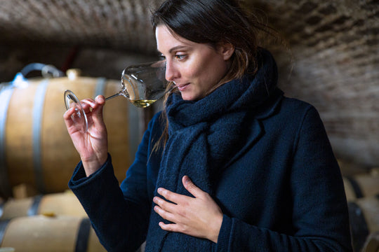 Alvina Pernot in the barrel room smelling wine from a glass