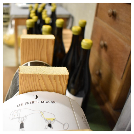 Label maker of Freres Mignon Champagnes with bottles with wax seals in the background