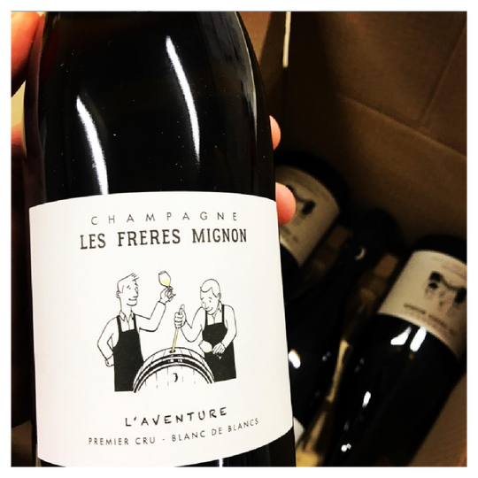 Hand holding a wine bottle of L'Aventure Champagne by Freres Mignon