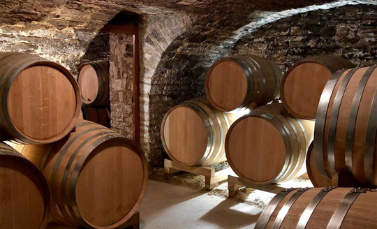 Wine aging room full of barrels in Domaine Joseph Colin